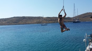 Rope swing while sailing in Greece at Kythnos